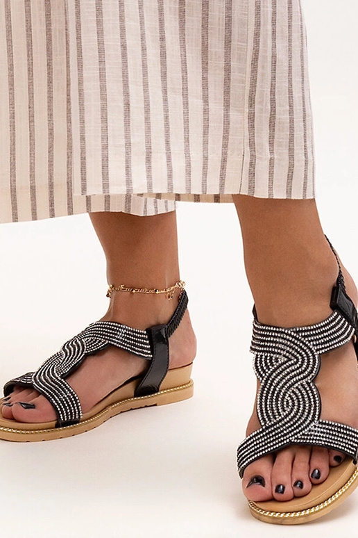 Mustad sandaalid, mis on kaunistatud...