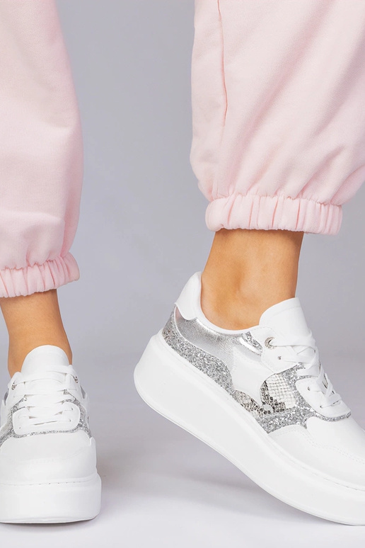 Valged spordijalatsid sädelevate ja...