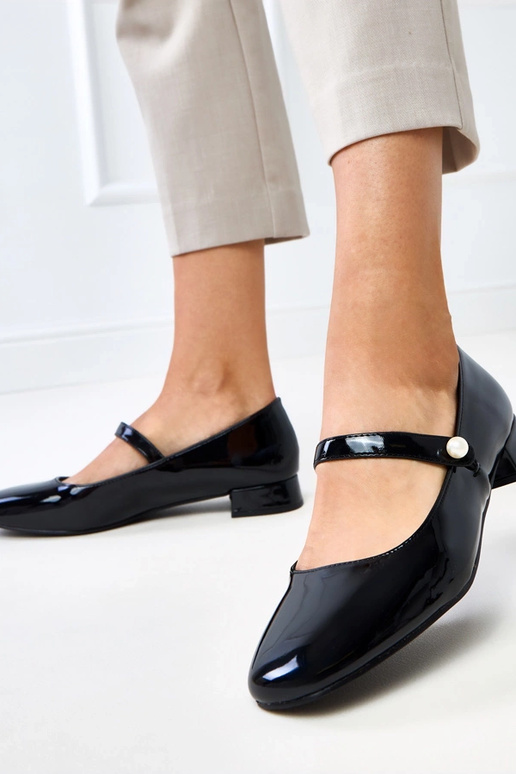 Musta lakattu korkokenkä hihnalla, Saga