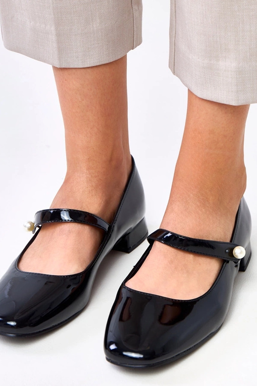 Musta lakattu korkokenkä hihnalla, Saga